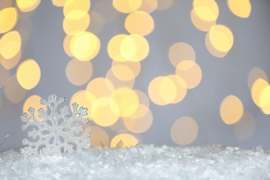 Beautiful decorative snowflake against blurred festive lights, space for text Photo of Beautiful decorative snowflake against blurred festive lights, space for text