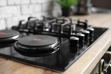 Photo of New modern stove with gas and electric burners in kitchen