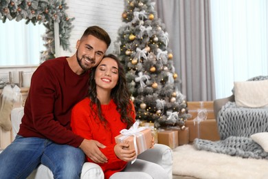 Lovely couple celebrating Christmas together at home Image of Lovely couple celebrating Christmas together at home