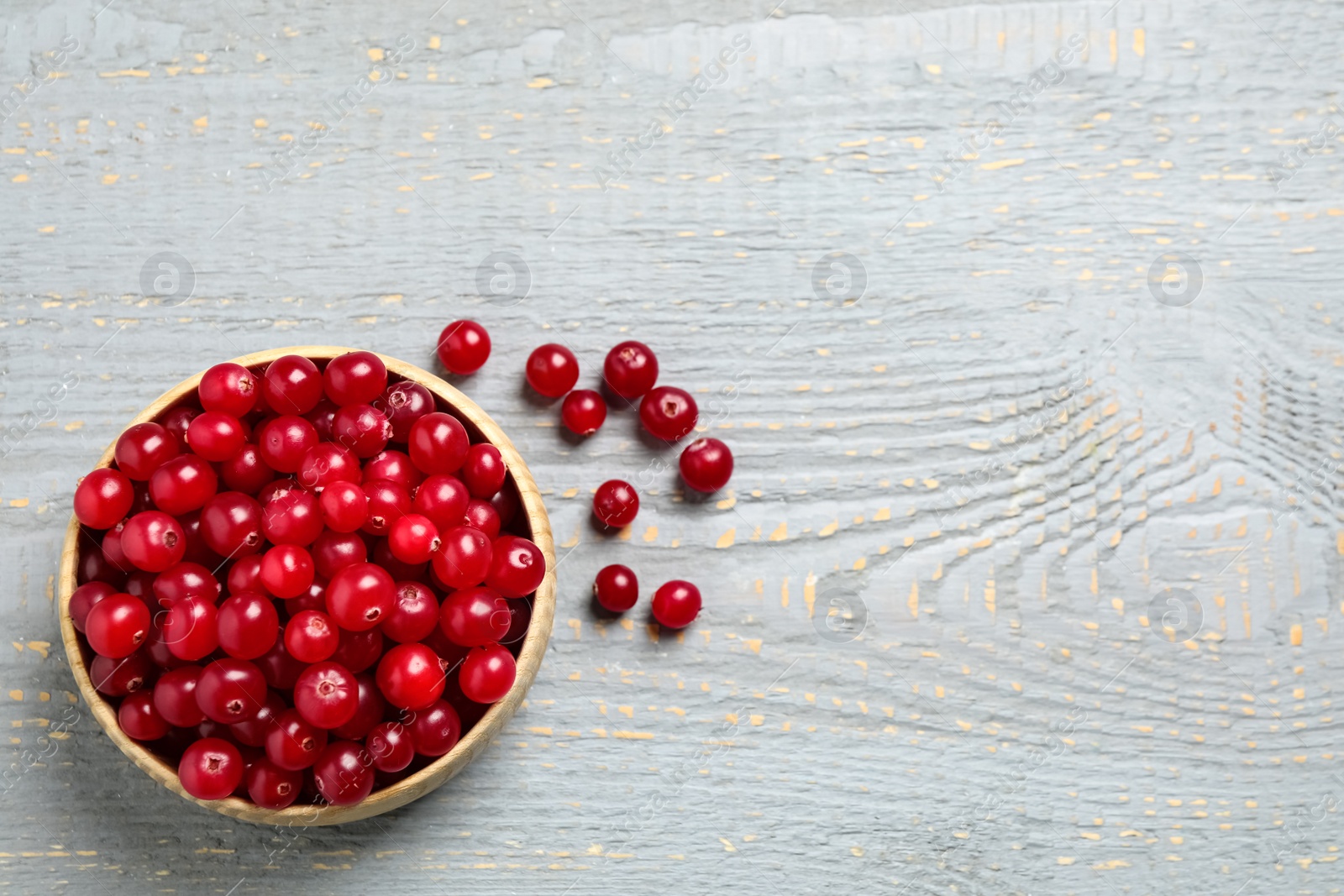 Tasty ripe cranberries on grey wooden table, flat lay. Space for text Photo of Tasty ripe cranberries on grey wooden table, flat lay. Space for text