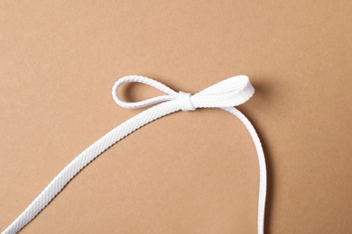 White shoelace on brown background, top view Photo of White shoelace on brown background, top view
