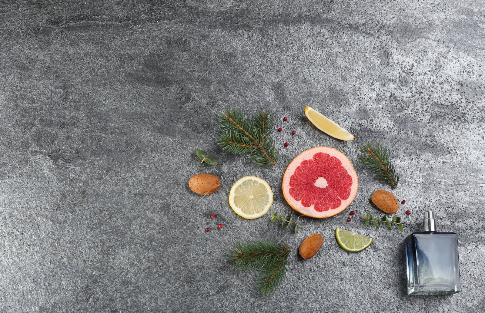 Photo of Flat lay composition with bottle of perfume on grey background, space for text