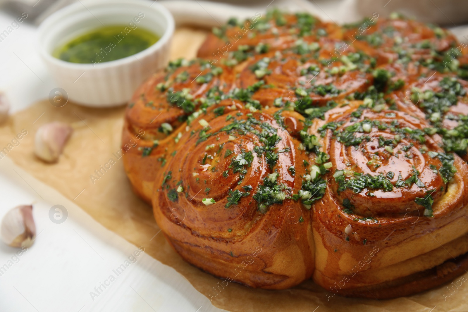 Traditional Ukrainian garlic bread with herbs (Pampushky) on white wooden table, closeup Photo of Traditional Ukrainian garlic bread with herbs (Pampushky) on white wooden table, closeup