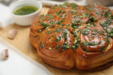 Traditional Ukrainian garlic bread with herbs (Pampushky) on white wooden table, closeup Photo of Traditional Ukrainian garlic bread with herbs (Pampushky) on white wooden table, closeup