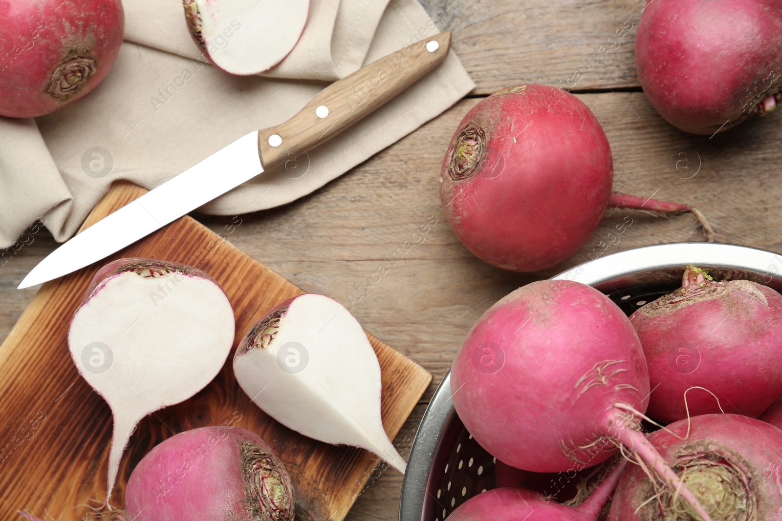 Red turnips and knife on wooden table, flat lay Photo of Red turnips and knife on wooden table, flat lay