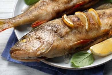 Tasty homemade roasted perches on white table, closeup. River fish Photo of Tasty homemade roasted perches on white table, closeup. River fish