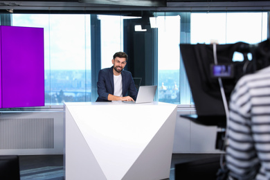 Presenter and video camera operator working in studio. News broadcasting Photo of Presenter and video camera operator working in studio. News broadcasting