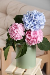Beautiful hortensia flowers in can on stand indoors Photo of Beautiful hortensia flowers in can on stand indoors