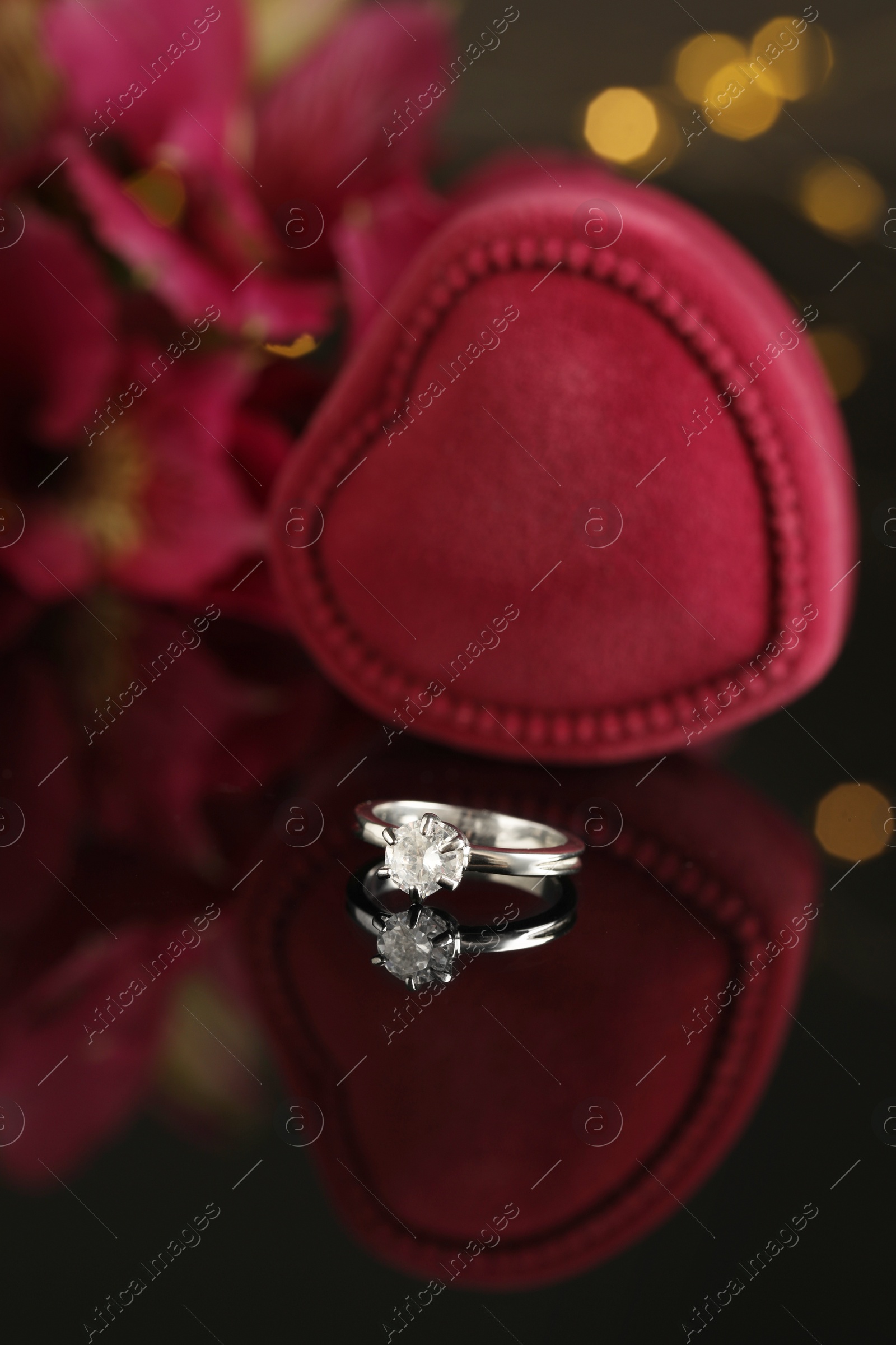Beautiful engagement ring against blurred festive lights Photo of Beautiful engagement ring against blurred festive lights