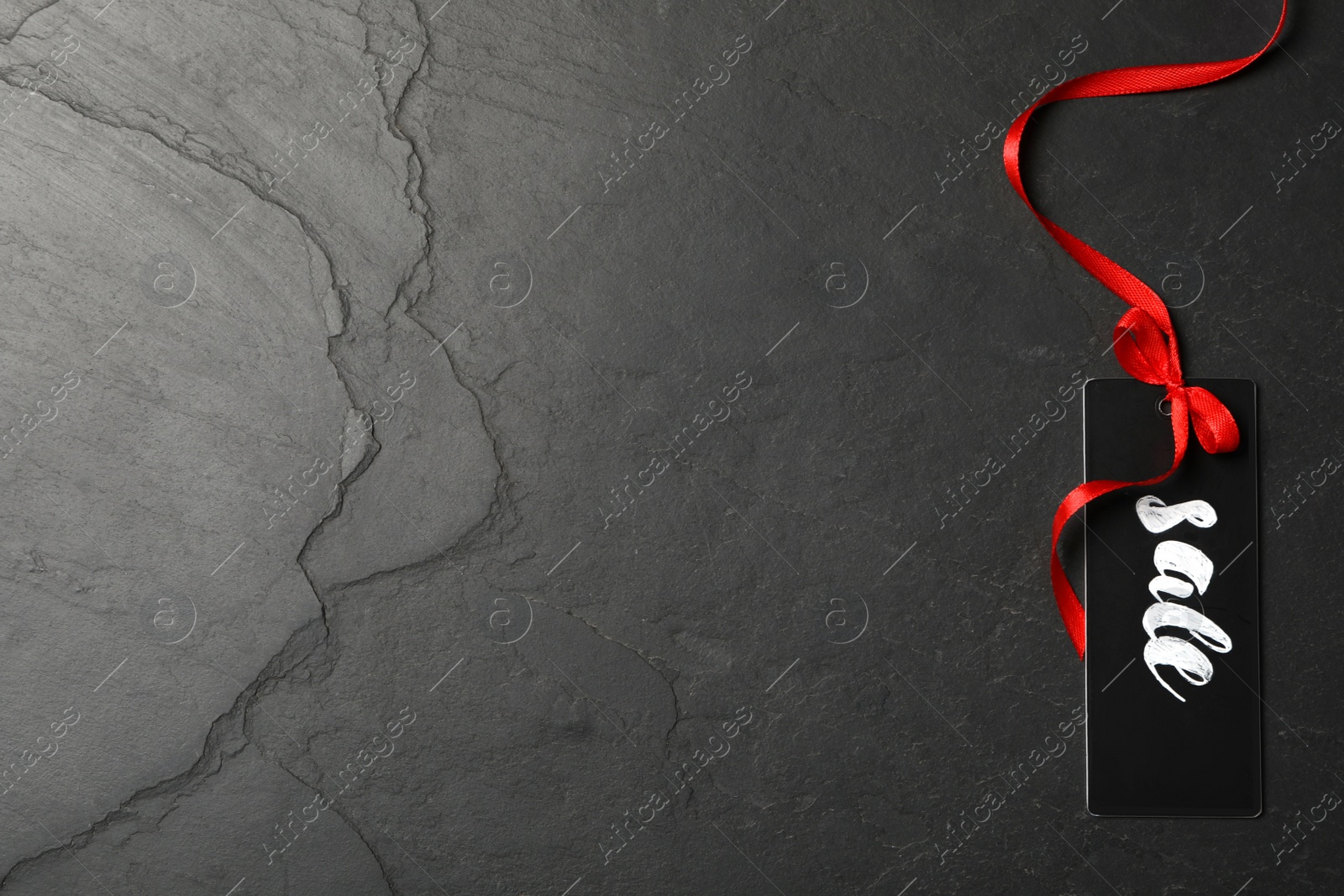 Photo of Tag with word Sale and space for text on dark background, top view. Black Friday concept