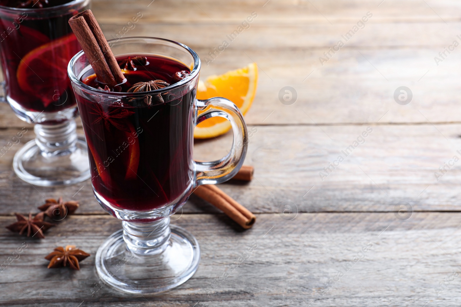 Delicious red mulled wine on wooden table. Space for text Photo of Delicious red mulled wine on wooden table. Space for text