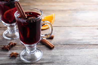 Delicious red mulled wine on wooden table. Space for text Photo of Delicious red mulled wine on wooden table. Space for text