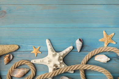 Beautiful sea stars, shells and rope on blue wooden background, flat lay. Space for text Photo of Beautiful sea stars, shells and rope on blue wooden background, flat lay. Space for text