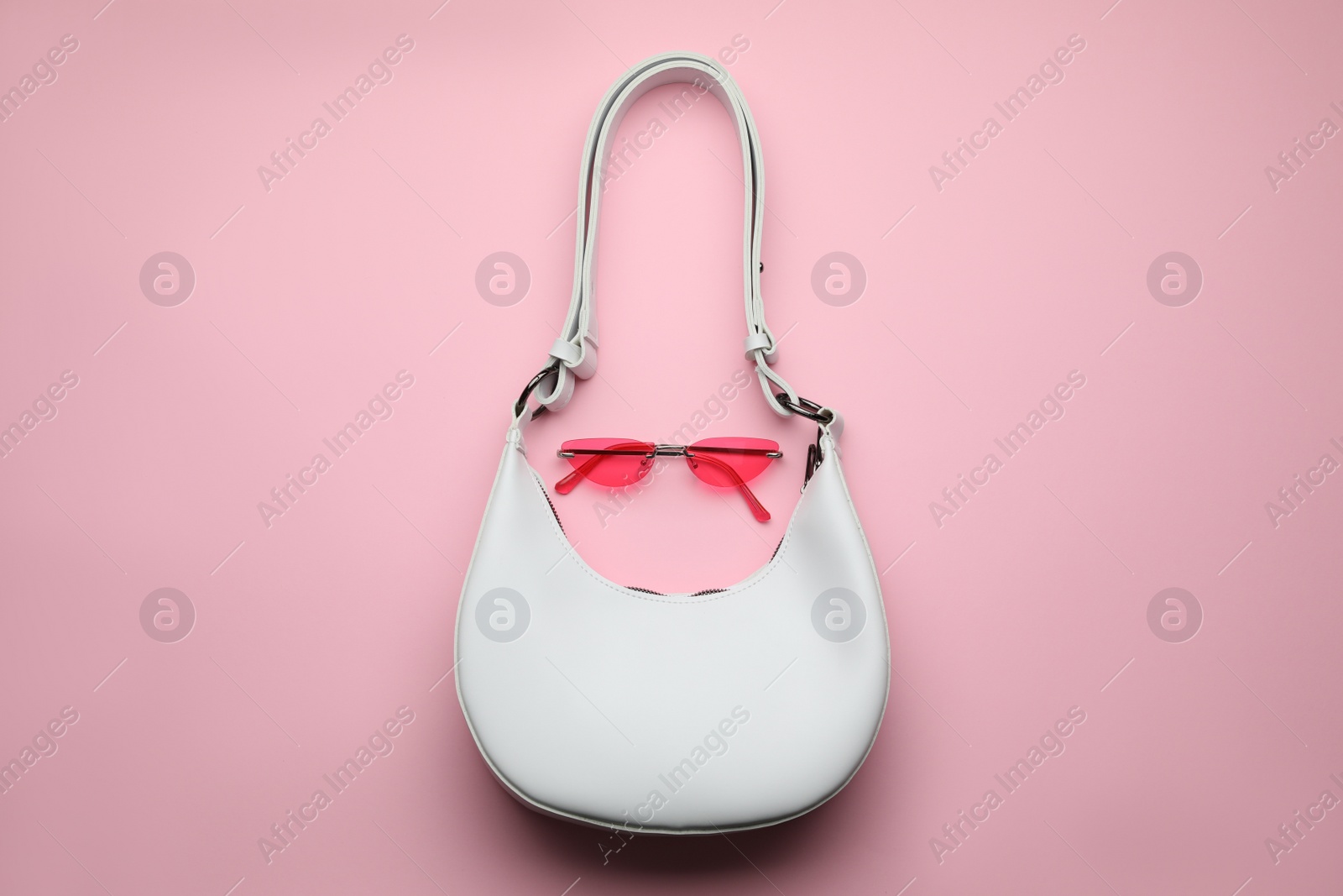 Stylish woman's bag and sunglasses on pink background, top view Photo of Stylish woman's bag and sunglasses on pink background, top view