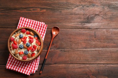 Tasty oatmeal porridge with berries and almond nuts served on wooden table, flat lay. Space for text Photo of Tasty oatmeal porridge with berries and almond nuts served on wooden table, flat lay. Space for text