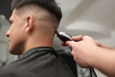 Professional barber making stylish haircut in salon, closeup Photo of Professional barber making stylish haircut in salon, closeup
