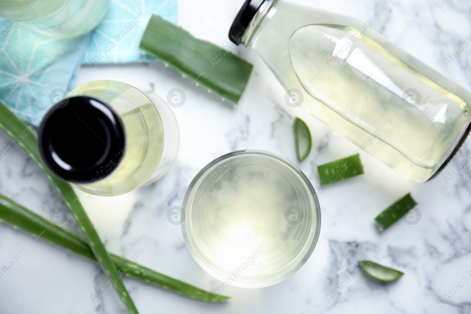 Fresh aloe drink and leaves on white marble table, flat lay Photo of Fresh aloe drink and leaves on white marble table, flat lay