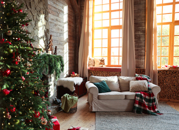 Festive interior with comfortable sofa and decorated Christmas tree Photo of Festive interior with comfortable sofa and decorated Christmas tree