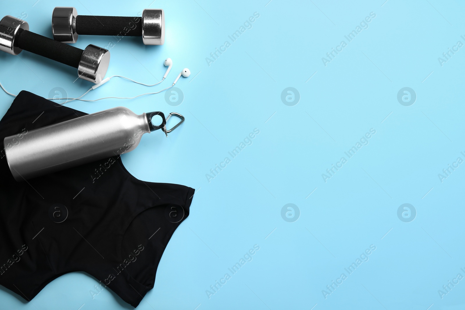 Flat lay composition with sportswear and dumbbells on light blue background, space for text. Gym workout Photo of Flat lay composition with sportswear and dumbbells on light blue background, space for text. Gym workout