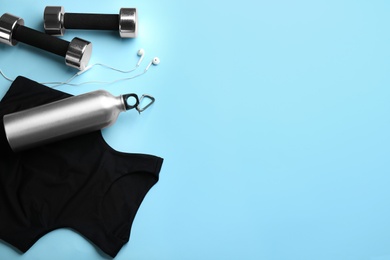 Flat lay composition with sportswear and dumbbells on light blue background, space for text. Gym workout Photo of Flat lay composition with sportswear and dumbbells on light blue background, space for text. Gym workout
