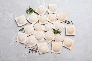 Uncooked ravioli, rosemary and peppercorns on grey marble table, flat lay Photo of Uncooked ravioli, rosemary and peppercorns on grey marble table, flat lay