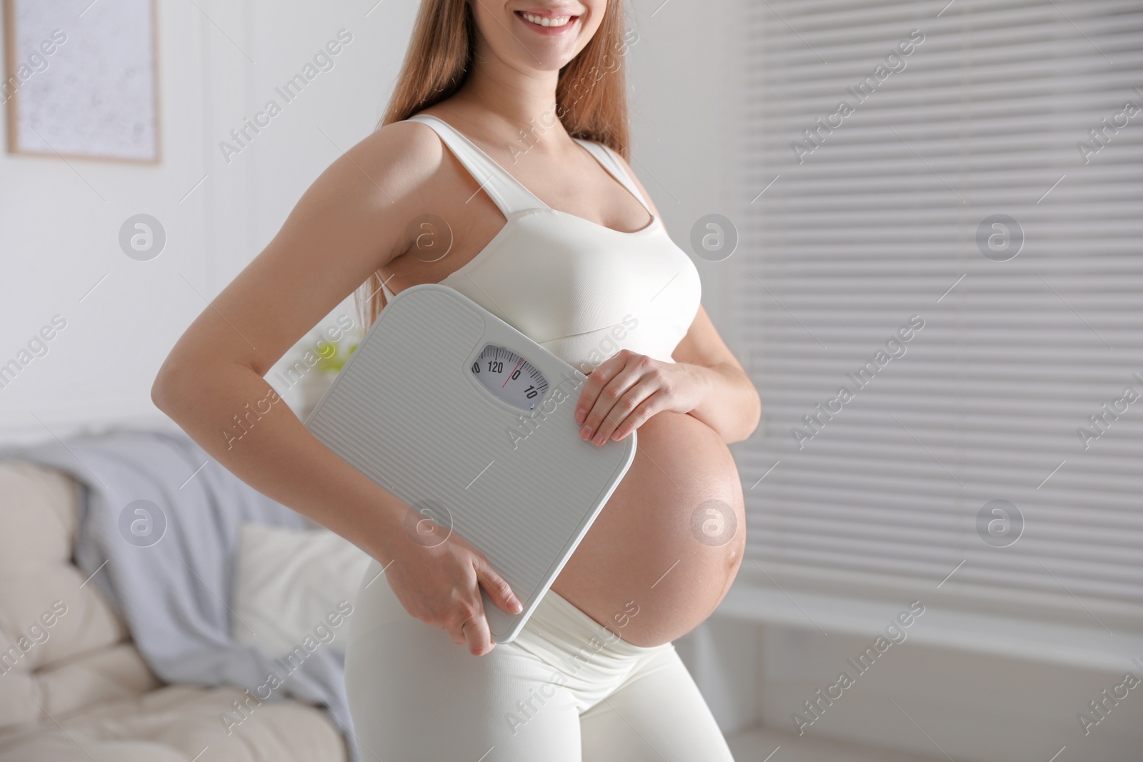 Young pregnant woman with scales at home, closeup Photo of Young pregnant woman with scales at home, closeup