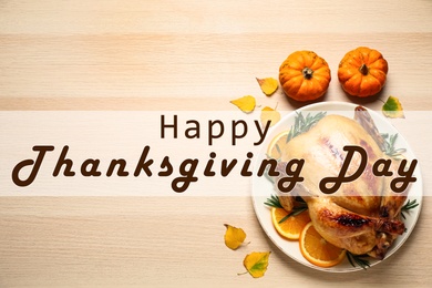 Happy Thanksgiving Day card. Traditional cooked turkey and autumn decor on wooden table, flat lay Image of Happy Thanksgiving Day card. Traditional cooked turkey and autumn decor on wooden table, flat lay