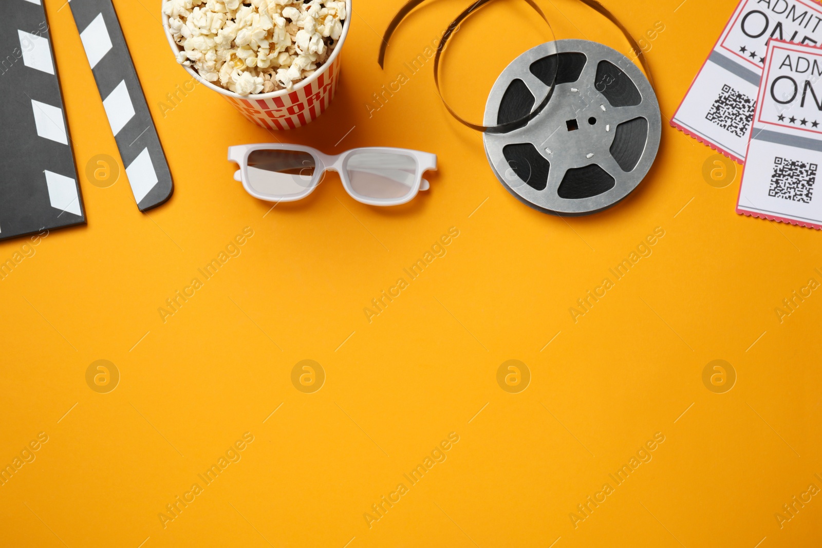 Flat lay composition with popcorn and film reel on orange background, space for text Photo of Flat lay composition with popcorn and film reel on orange background, space for text
