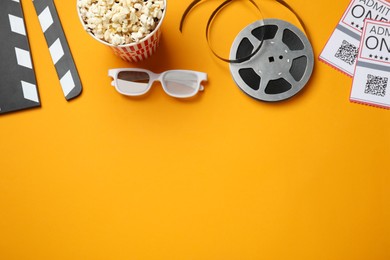 Flat lay composition with popcorn and film reel on orange background, space for text Photo of Flat lay composition with popcorn and film reel on orange background, space for text
