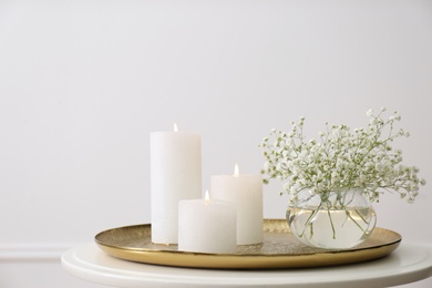 Vase with beautiful flowers and burning candles on table indoors. Interior elements Photo of Vase with beautiful flowers and burning candles on table indoors. Interior elements