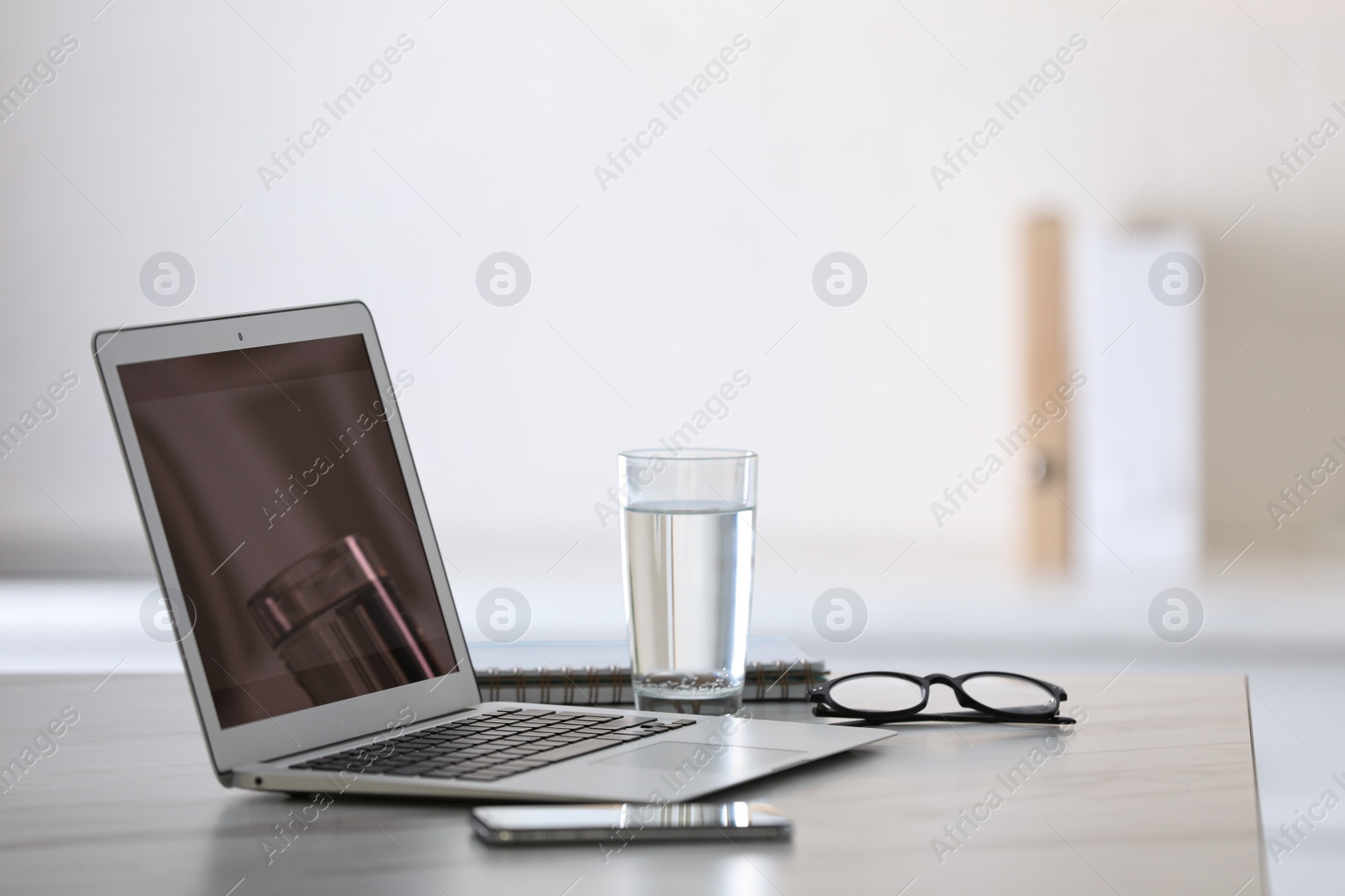Modern workplace with laptop on grey table in office Photo of Modern workplace with laptop on grey table in office
