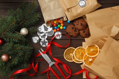 Flat lay composition with gift bags, treats and Christmas decor on wooden table. Creating advent calendar Photo of Flat lay composition with gift bags, treats and Christmas decor on wooden table. Creating advent calendar