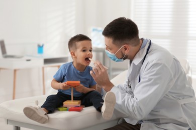 Pediatrician examining cute little boy at hospital Photo of Pediatrician examining cute little boy at hospital