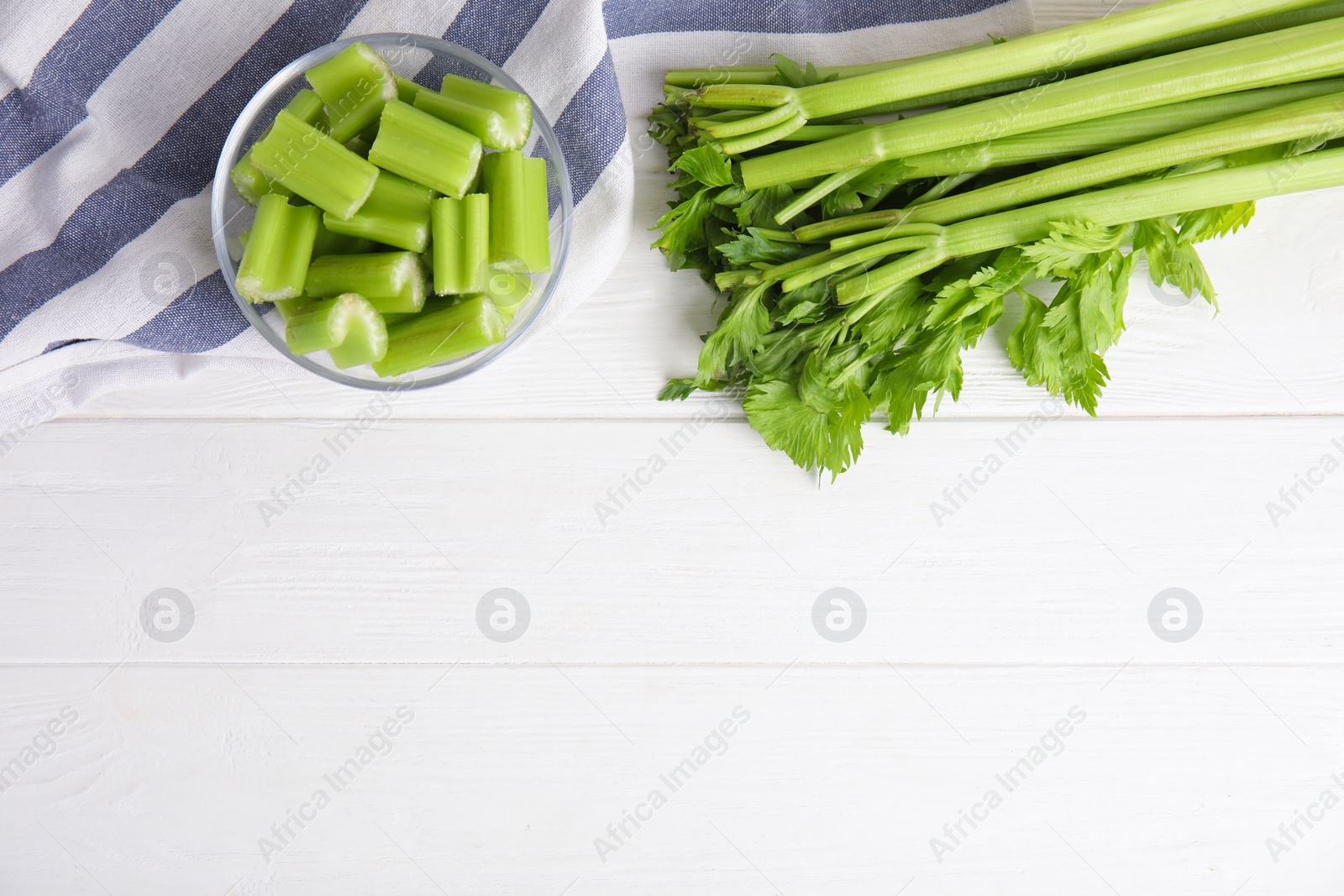 Fresh ripe green celery on white wooden table, flat lay. Space for text Photo of Fresh ripe green celery on white wooden table, flat lay. Space for text