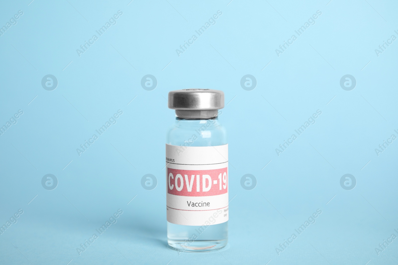 Photo of Vial with coronavirus vaccine on light blue background