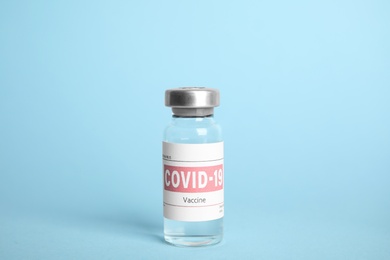 Vial with coronavirus vaccine on light blue background Photo of Vial with coronavirus vaccine on light blue background