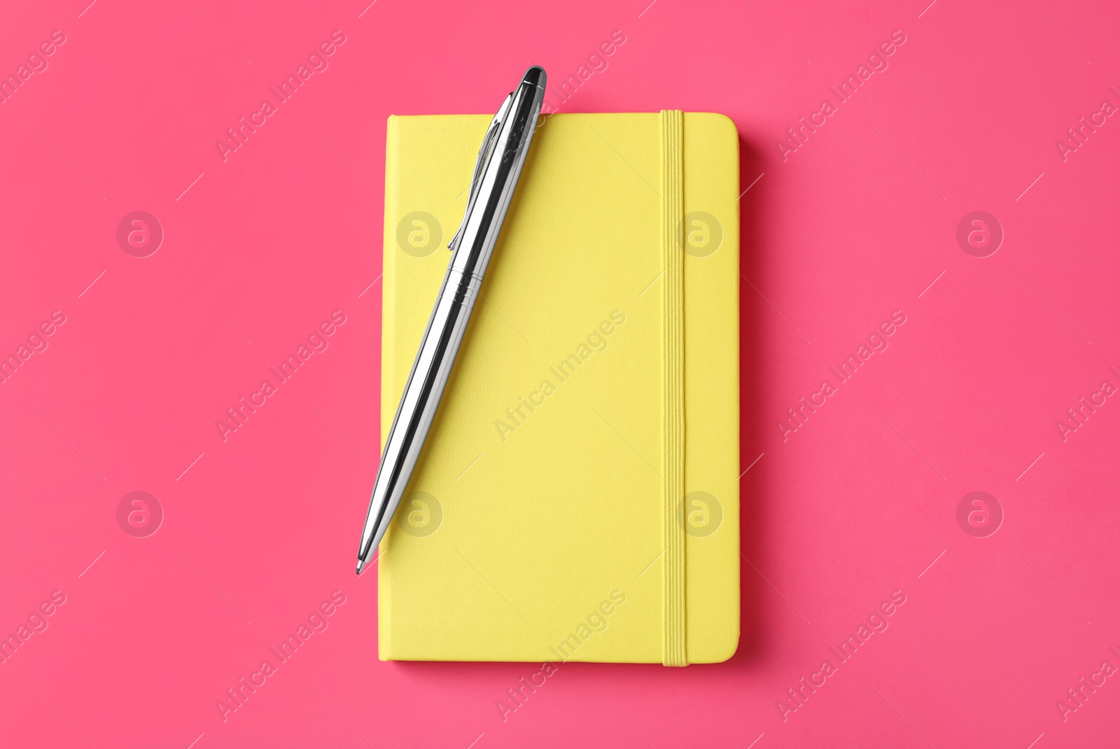 New stylish planner with hard cover and pen on pink background, top view Photo of New stylish planner with hard cover and pen on pink background, top view