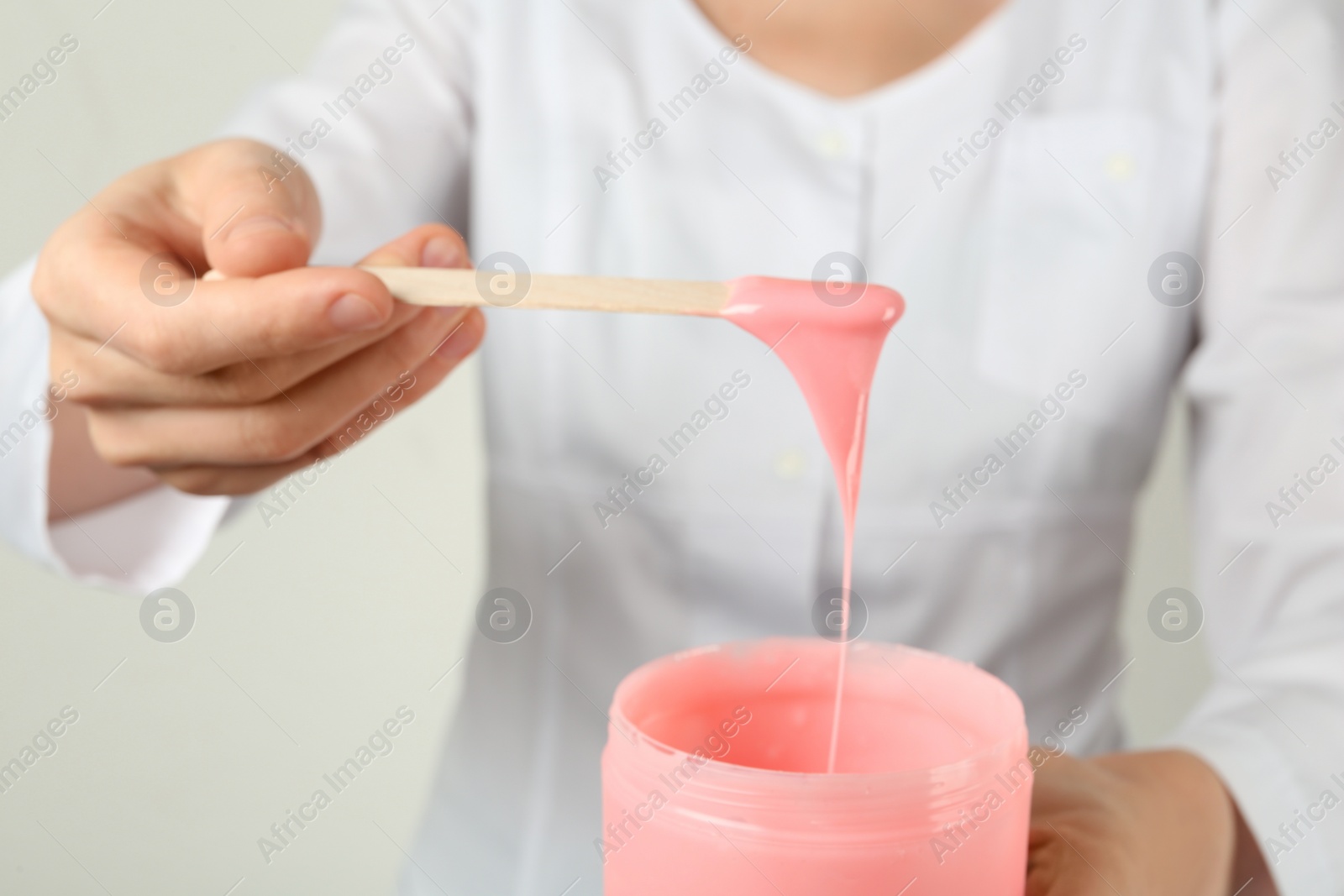 Woman holding spatula with hot depilatory wax, closeup Photo of Woman holding spatula with hot depilatory wax, closeup