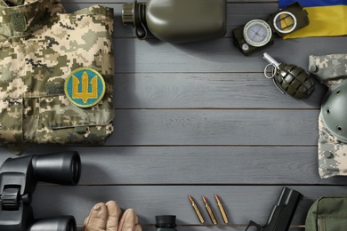 MYKOLAIV, UKRAINE - SEPTEMBER 26, 2020: Frame of tactical gear and Ukrainian military uniform on grey table, flat lay. Space for text Photo of MYKOLAIV, UKRAINE - SEPTEMBER 26, 2020: Frame of tactical gear and Ukrainian military uniform on grey table, flat lay. Space for text