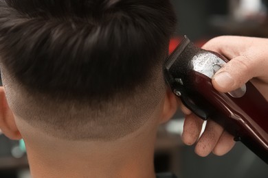 Professional barber making stylish haircut in salon, closeup Photo of Professional barber making stylish haircut in salon, closeup