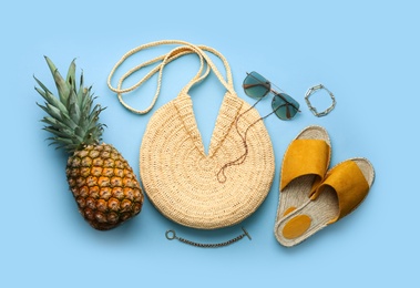 Flat lay composition with woman's straw bag on light blue background Photo of Flat lay composition with woman's straw bag on light blue background