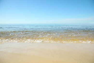 Sea wave rolling on sandy beach in summer, closeup Photo of Sea wave rolling on sandy beach in summer, closeup