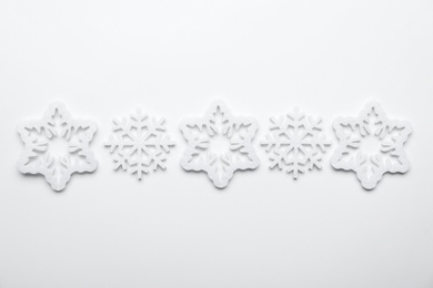 Beautiful decorative snowflakes on white background, flat lay Photo of Beautiful decorative snowflakes on white background, flat lay