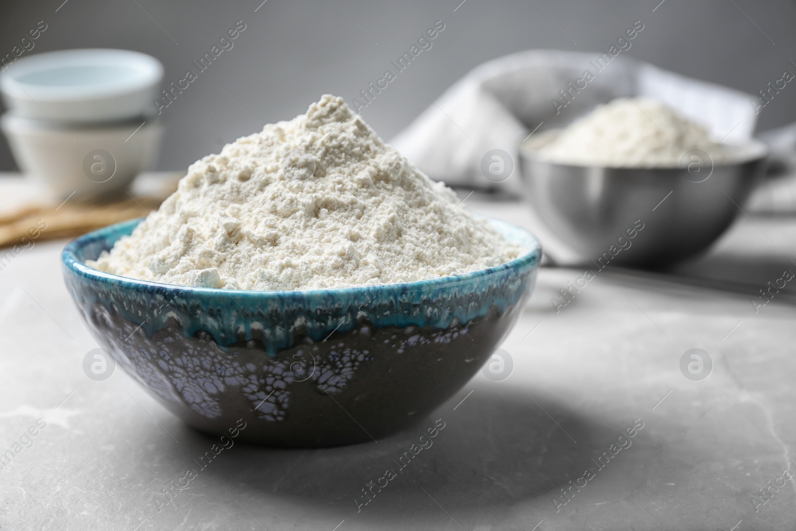 Ceramic bowl with flour on table Photo of Ceramic bowl with flour on table