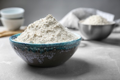 Ceramic bowl with flour on table Photo of Ceramic bowl with flour on table