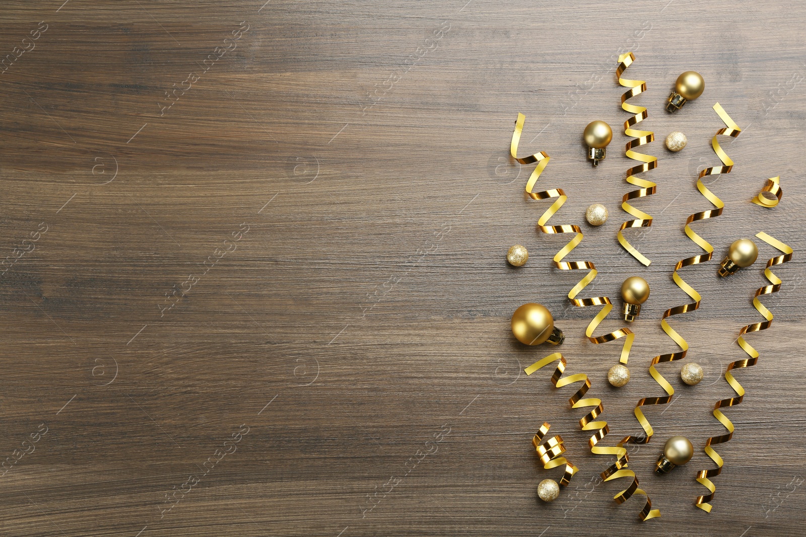 Shiny serpentine streamers and Christmas balls on wooden background, flat lay. Space for text Photo of Shiny serpentine streamers and Christmas balls on wooden background, flat lay. Space for text
