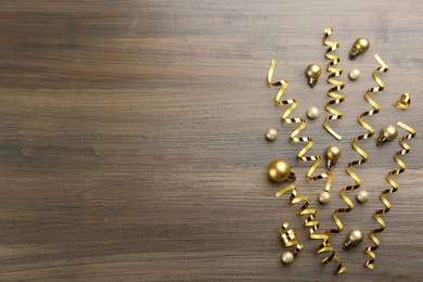 Shiny serpentine streamers and Christmas balls on wooden background, flat lay. Space for text Photo of Shiny serpentine streamers and Christmas balls on wooden background, flat lay. Space for text