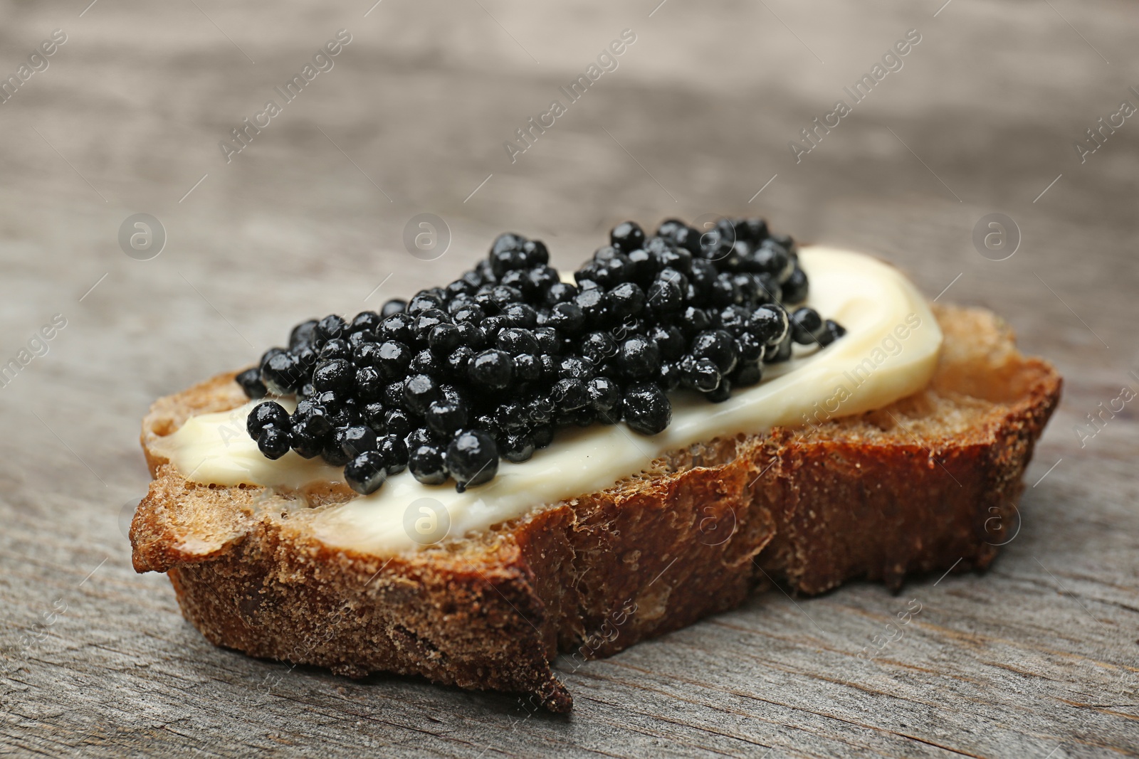Sandwich with black caviar on wooden background Photo of Sandwich with black caviar on wooden background