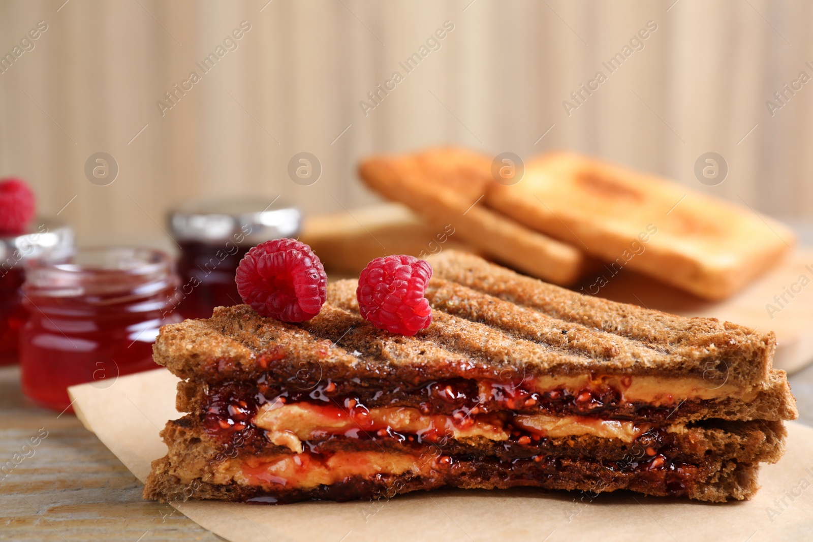 Tasty sandwich with raspberry jam and peanut butter for breakfast on table Image of Tasty sandwich with raspberry jam and peanut butter for breakfast on table