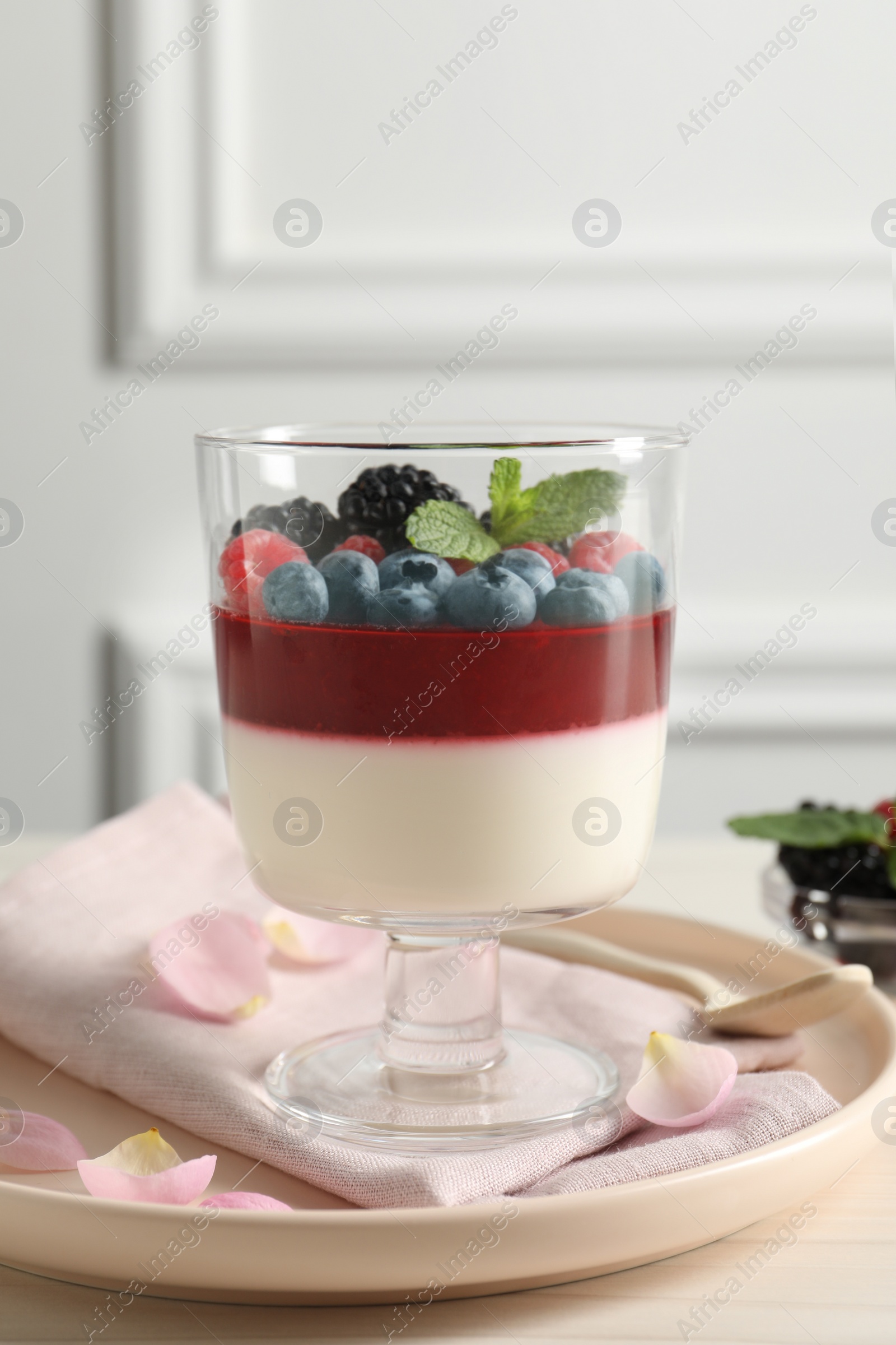 Delicious panna cotta with berries on light table Photo of Delicious panna cotta with berries on light table
